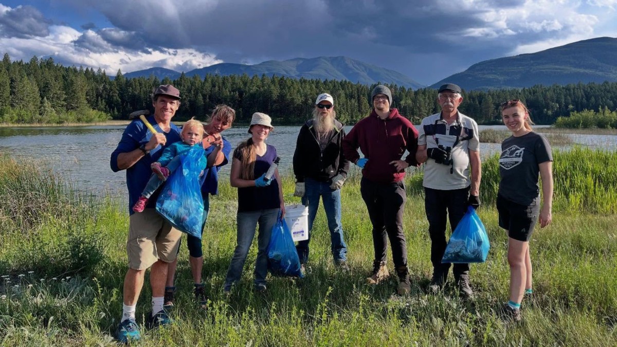 photo of volunteers standing in front of Lake Enid with garbage bags