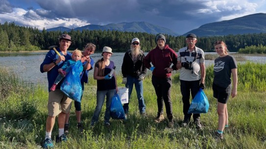 Photo of volunteers with garbage bags in front of Lake Enid