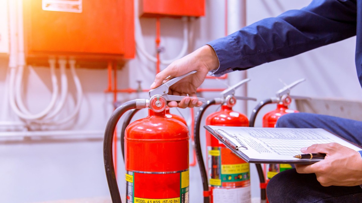 A hand holding a fire hydrant and a clipboard with checklist