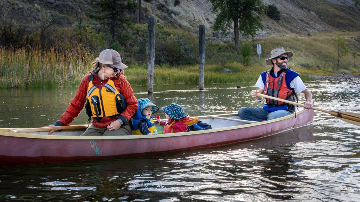 a family paddling a canoe on the river