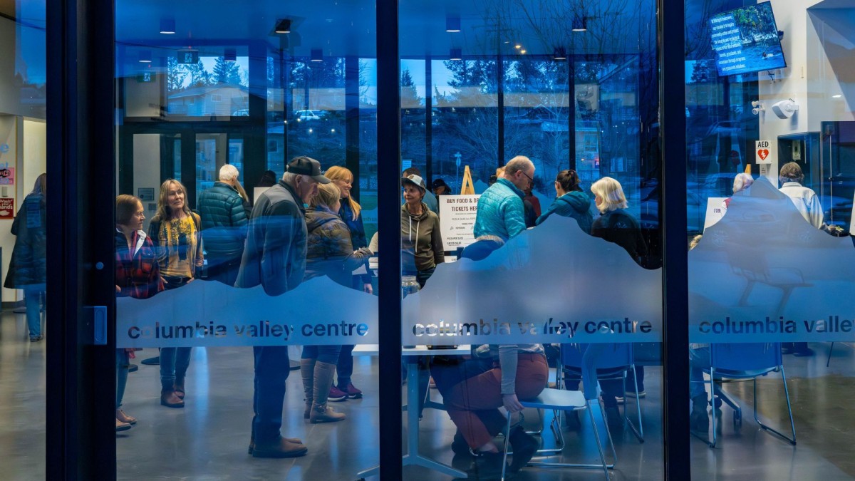 Looking through the  windows of the Columbia Valley Centre to people inside